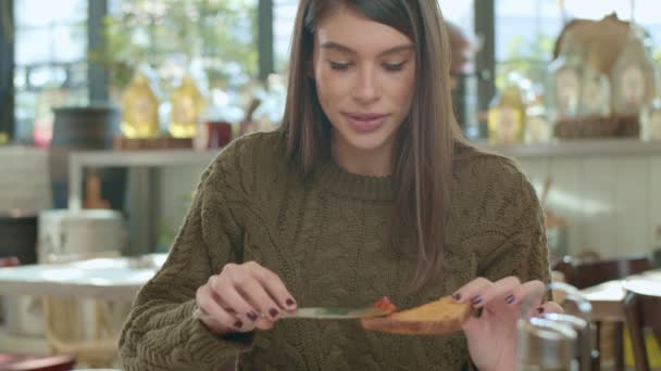 Kaukasisk Kvinna Äter Rostat Bröd Till Frukost Medan Hon Sitter — Stockvideo