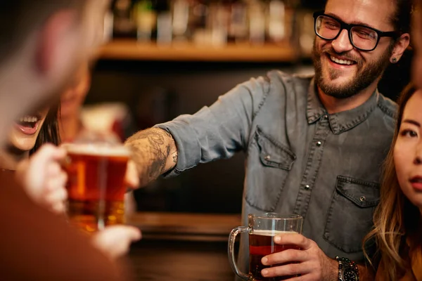 Grupo de amigos bebiendo cerveza, charlando y divirtiéndose en el pub. Noche fuera. . —  Fotos de Stock
