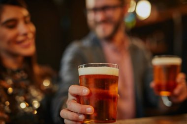 Adam grupta duruyor ve bir arkadaşına bira veriyor. İrlanda barının içi. Gece hayatı..