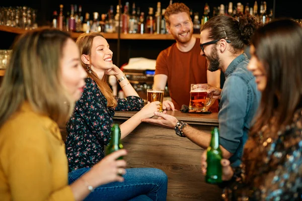 Grupo de amigos bebendo cerveja, conversando e se divertindo no pub. Noite fora . — Fotografia de Stock
