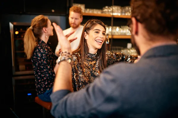 Un gruppo di amici che beve birra, chiacchiera e si diverte al pub. Notte fuori . — Foto Stock