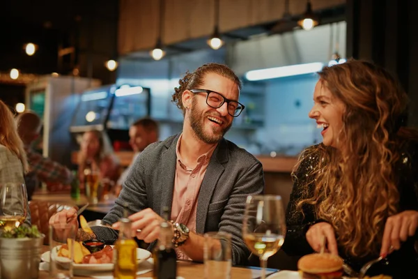 Beste Freunde sitzen zum Abendessen im Restaurant, trinken Wein und plaudern. — Stockfoto