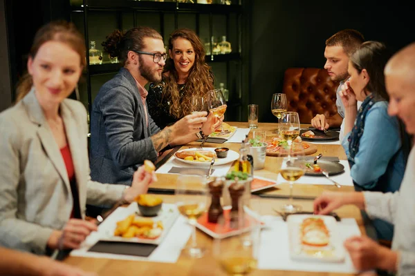 Legjobb barátok ülnek az étteremben vacsorára, bort isznak és beszélgetnek. — Stock Fotó