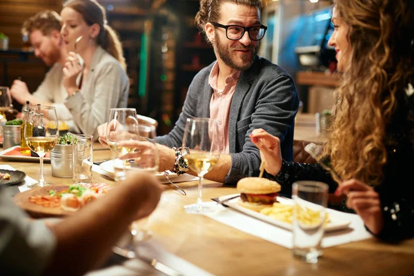 Beste Freunde sitzen zum Abendessen im Restaurant, trinken Wein und plaudern. — Stockfoto