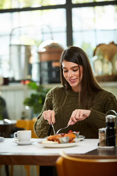 Aantrekkelijke brunette zitten in restaurant in de ochtend en ontbijten. — Stockfoto