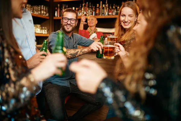 Grupo de amigos bebiendo cerveza, charlando y divirtiéndose en el pub. Noche fuera. . — Foto de Stock
