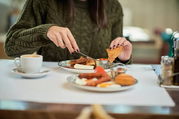 Imagen recortada de la morena caucásica comiendo tostadas francesas en el restaurante para el desayuno . — Foto de Stock