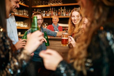 Bir grup arkadaş bira içiyor, sohbet ediyor ve barda iyi vakit geçiriyorlar. Gece dışarı.