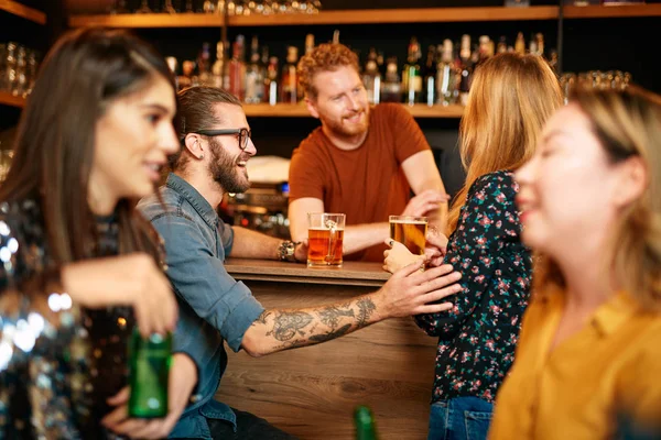 Skupina přátel pije pivo, klábosí a baví se v hospodě. Noc.. — Stock fotografie