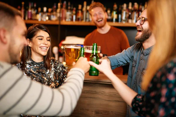 Amigos de pie en el bar y tostadas con cerveza . — Foto de Stock