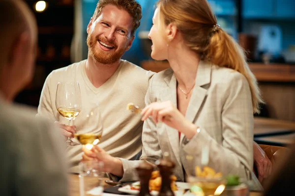 Grupo de mejores amigos sentados en el restaurante, cenando, bebiendo vino y divirtiéndose . — Foto de Stock