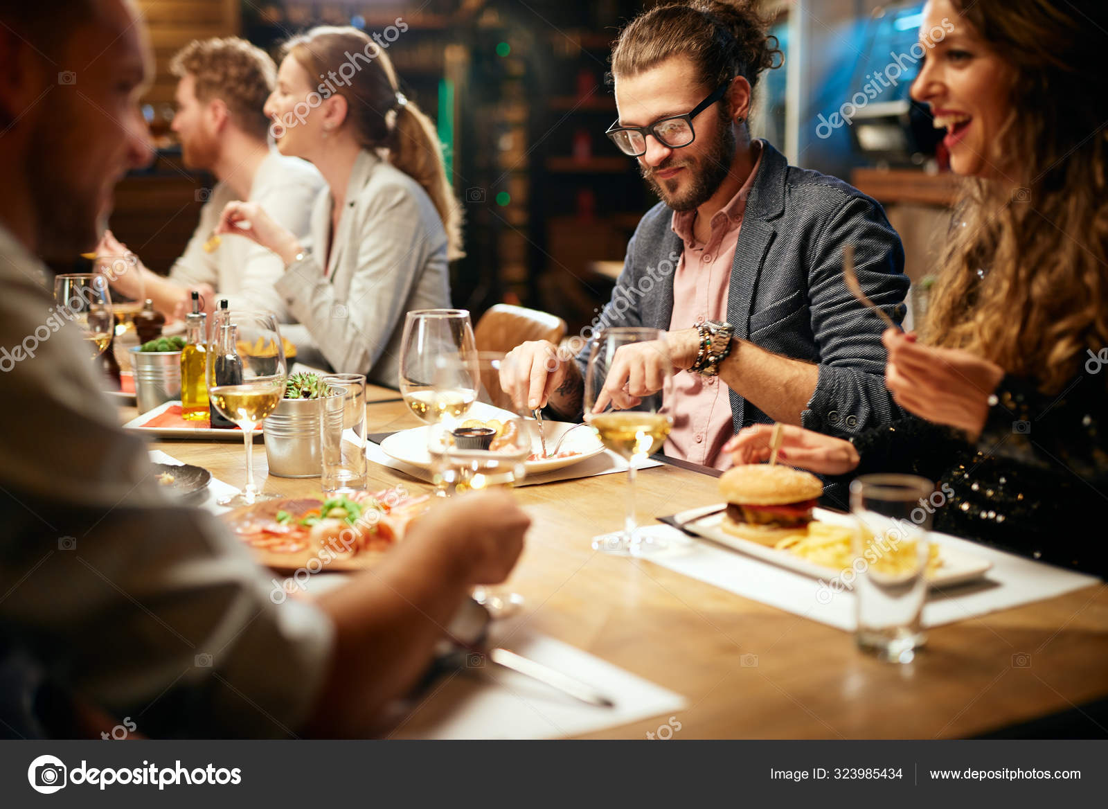 Garçonete bonita servindo grupo de amigas com comida no restaurante
