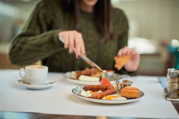 Primer plano de la mujer caucásica en suéter sentado en el restaurante y teniendo tostadas francesas para el desayuno . — Foto de Stock