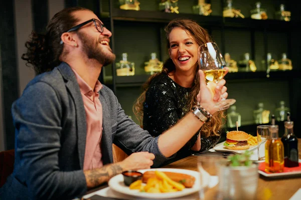 Bonito casal caucasiano sentado no restaurante e aplaudindo com vinho — Fotografia de Stock