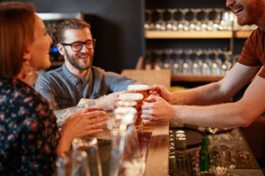 Barmen müşterilere bira servisi yapıyor. Bar içi..