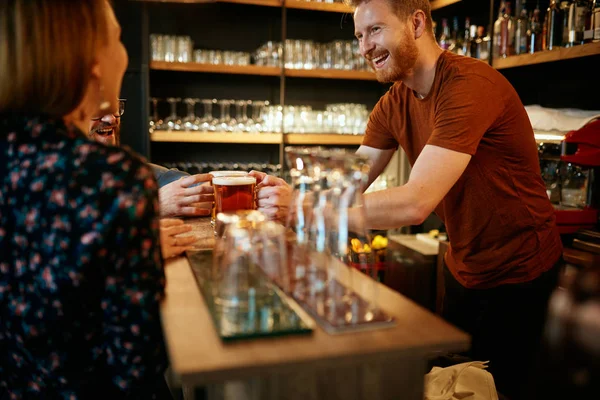 Empregado a servir cerveja aos clientes. Pub interior . — Fotografia de Stock