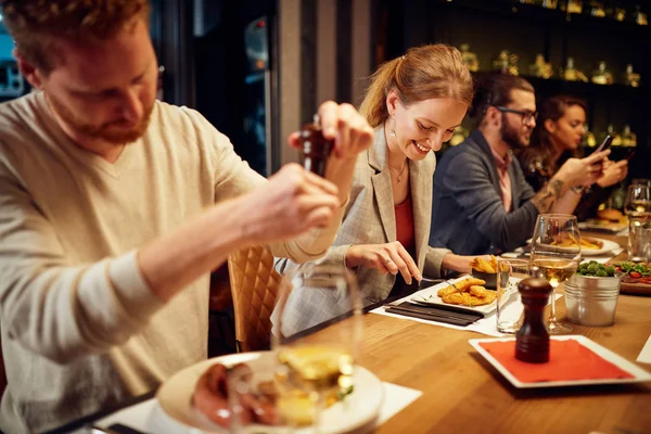 Group of friends sitting in retaurant and eating dinner. — Stock Photo, Image