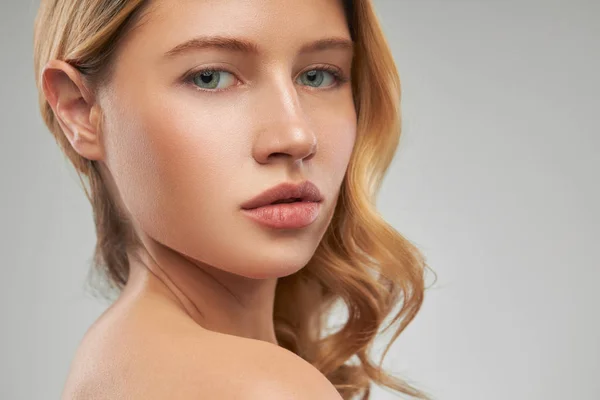 Gorgeous caucasian blond woman with makeup posing in studio and looking at camera.n blond woman with makeup posing in studio and — Stock Photo, Image