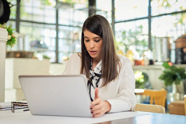 Giovane attraente gestore ristorante caucasico seduto a tavola e utilizzando il computer portatile per l'organizzazione di affari . — Foto Stock