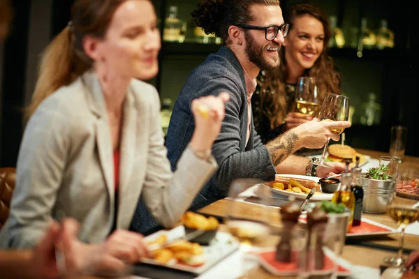 Beste vrienden zitten in restaurant voor het diner, wijn drinken en chatten. — Stockfoto