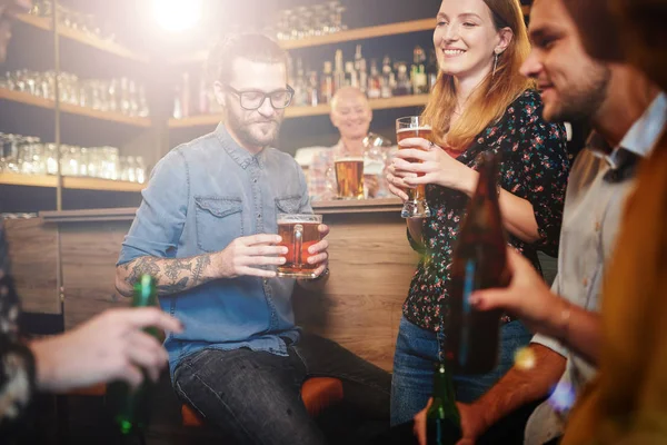 Grupo de amigos bebiendo cerveza, charlando y divirtiéndose en el pub. Noche fuera. . — Foto de Stock