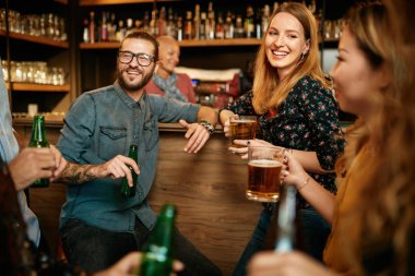 Bir grup arkadaş bira içiyor, sohbet ediyor ve barda iyi vakit geçiriyorlar. Gece dışarı.