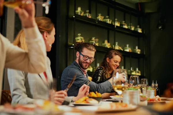 Gruppe bester Freunde sitzt im Restaurant, isst zu Abend, trinkt Wein und hat Spaß. — Stockfoto