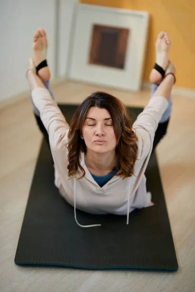 Attraktive ruhige Brünette mittleren Alters in Bogen-Yoga-Pose. — Stockfoto