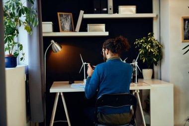 Hippi 'nin ofisinde oturup proje üzerinde çalışmasını ve akıllı telefonu duraklatmak için kullanmasını. Sürdürülebilir geliştirme kavramı.