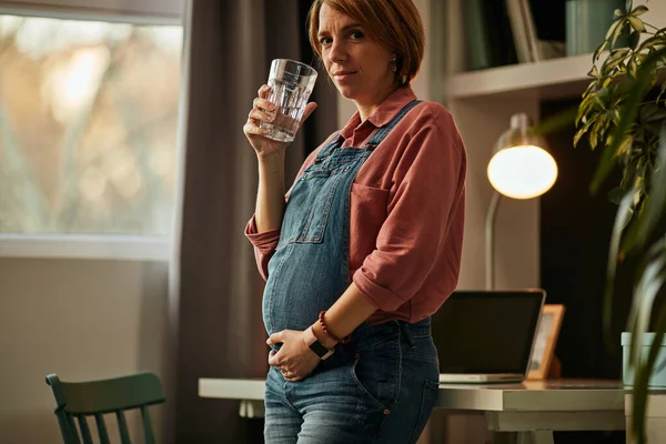Mujer Embarazada Pie Oficina Casa Tocando Vientre Bebiendo Agua Dulce —  Fotos de Stock