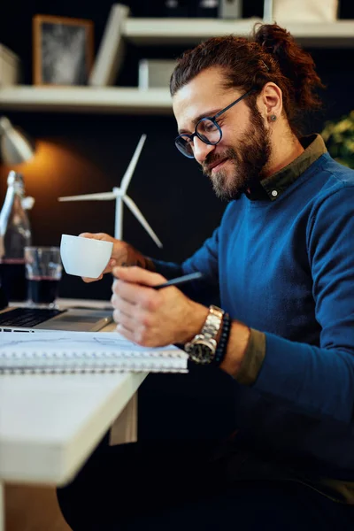 Jonge Glimlachende Blanke Hipster Zit Zijn Kantoor Drinkt Koffie Tekent — Stockfoto