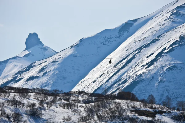 Kamçatka yarımadasında dağlarda uçan helikopter — Stok fotoğraf