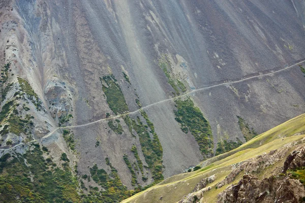 Estrada abandonada velha ao longo de uma encosta íngreme com scree rochoso — Fotografia de Stock