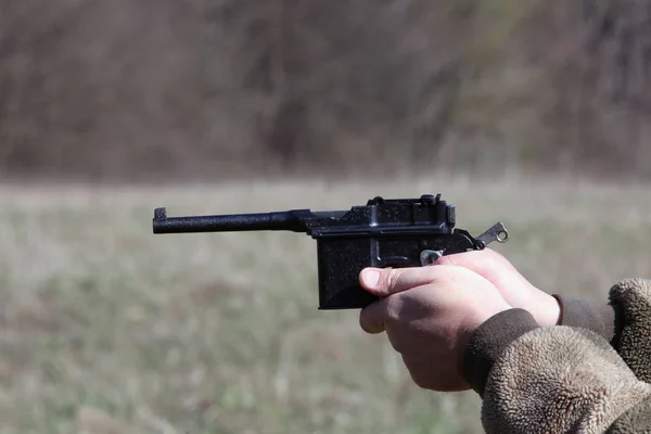 Old black gun in his hand before the shot