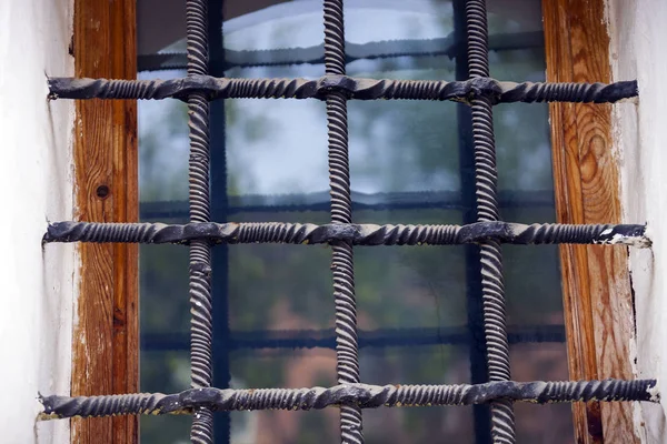 Ancient window with metal bars. Pskov, Russia,