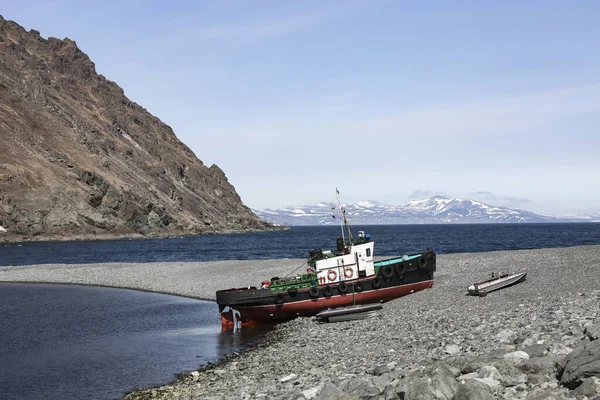 小海拖充气肋和金属船在低潮的海滩上 马加丹地区Okhotsk海页岩海岸的海上运输船和船只 — 图库照片
