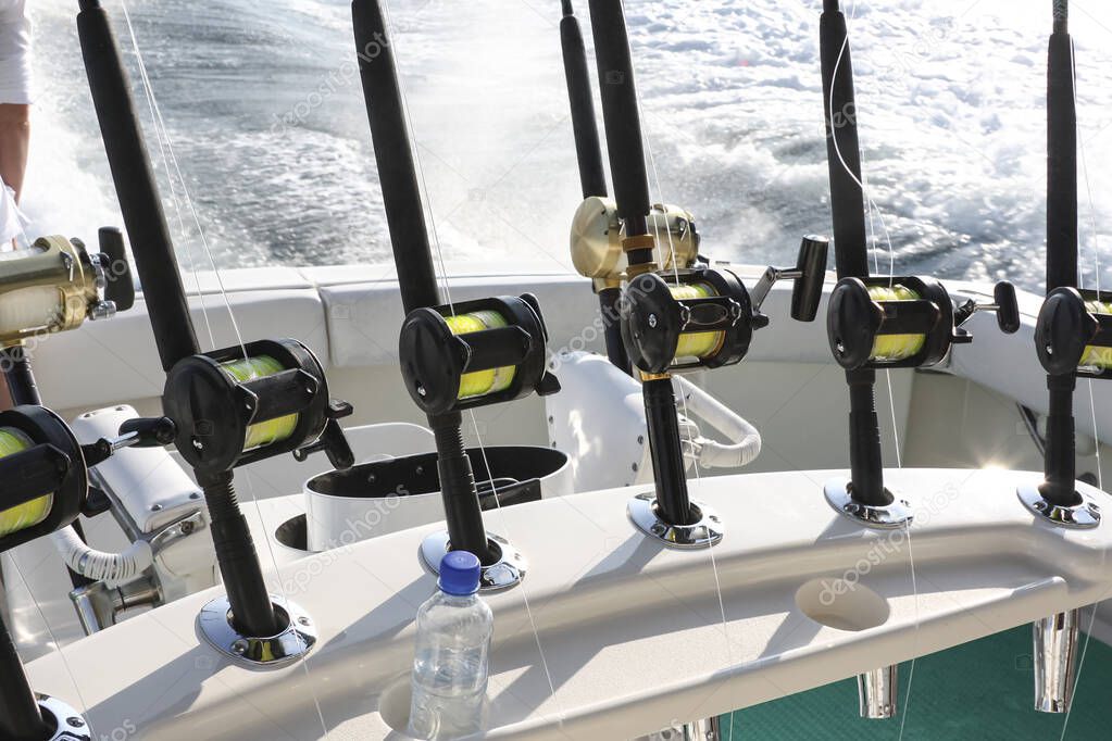 Spinning rods with reels installed in holders before fishing on a boat. Equipment for sea trophy fishing on a fishing yacht.