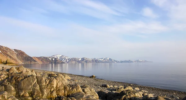 春にはオホーツク海の海岸線や海岸線を一望できます ロシアの北東部の水の端にある岩 — ストック写真