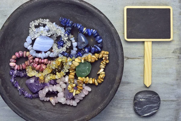 Collection of gem stones and crystals on a grey wooden background with zen cairn stones