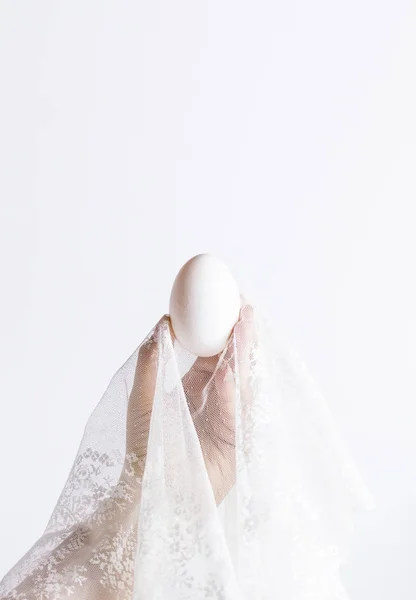 Un huevo en encaje en la mano —  Fotos de Stock