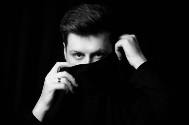 Balıkçı yakalı şık bir adam. Siyah arkaplan.