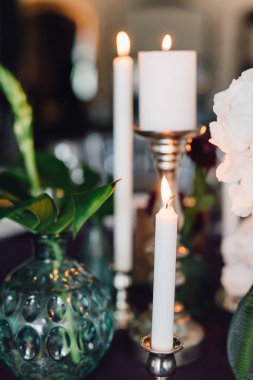 Closeup mumlar ve menekşe bezle şenlikli masaya çiçek