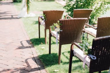 Düğün töreni için çiçeklerle süslü sandalyeler