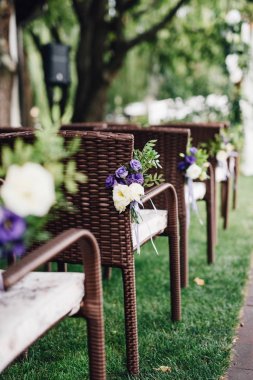 Düğün töreni için çiçeklerle süslü sandalyeler