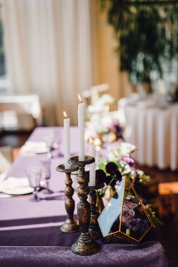 Düğün masa ile florariums, closeup beyaz mumlar, Festival sofra ve mor bez