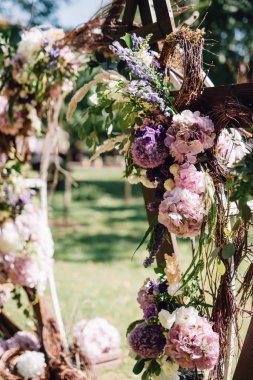 Şenlikli dallarında yapılan düğün kemer dekore edilmiş ve gül ve peonies mor