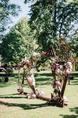 Şenlikli dallarında yapılan düğün kemer dekore edilmiş ve gül ve peonies mor