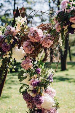 Şenlikli dallarında yapılan düğün kemer dekore edilmiş ve gül ve peonies mor