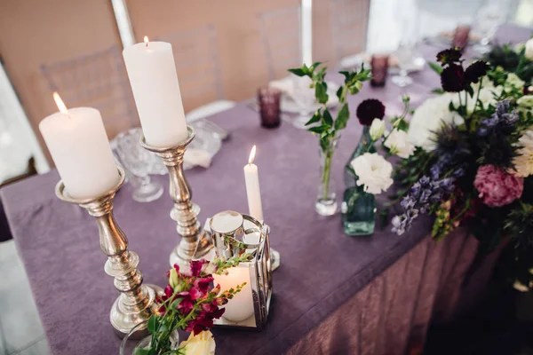 紫の布でテーブルの上の花 ろうそく 豊富な食器をお祭りの装飾 — ストック写真