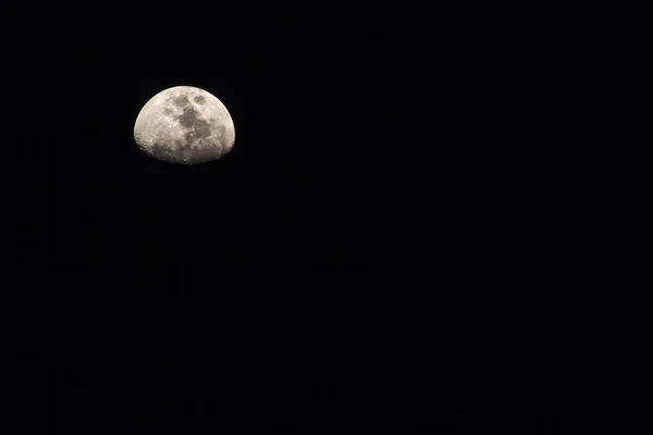 Moon. Half Moon Shrouded in Darkness on Black background